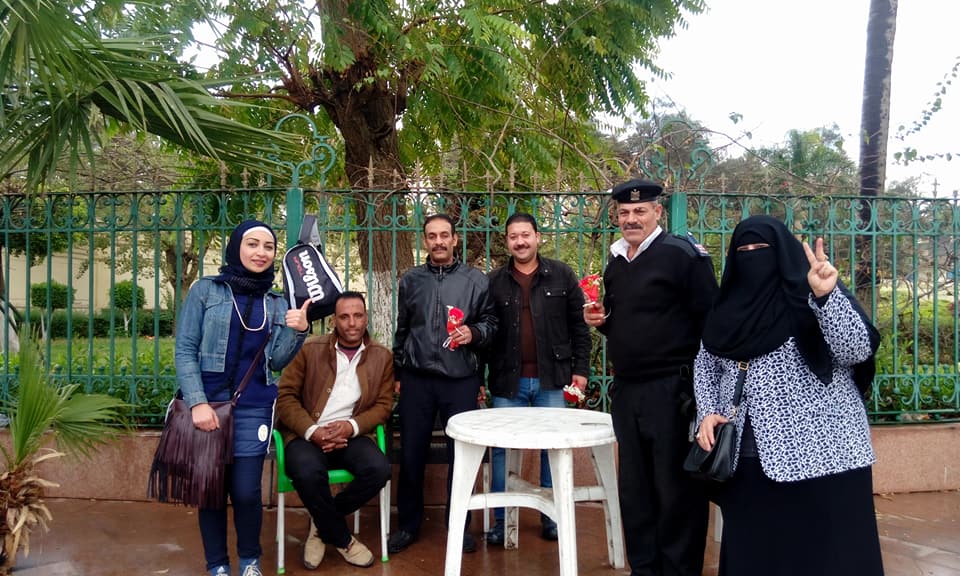 فريق ارسم بسمة توزيع الزهور على ضباط الشرطة في ميدان حدائق القبة